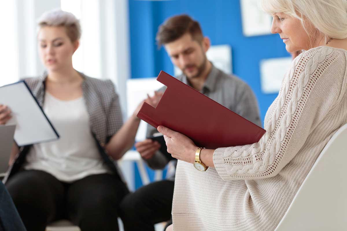 Réunion de personnes regardant un cahier