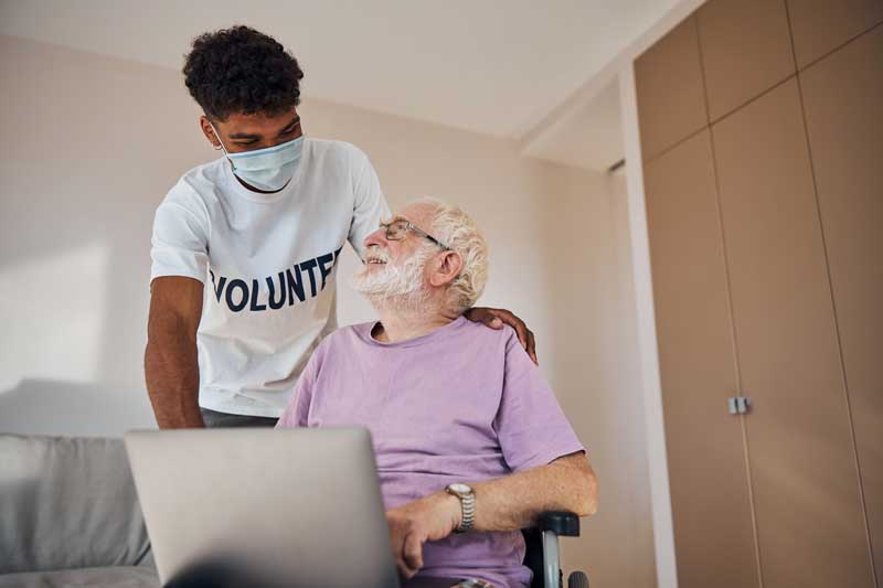 Jeune bénévole qui aide une personne âgée